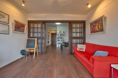 a living room with a red couch and a table at Sofia center best view by Flat Mаnager in Sofia