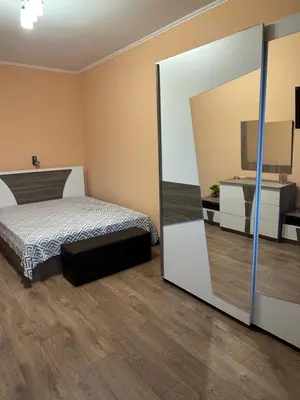 a bedroom with a bed and a large mirror at Къща за гости Арнаудови in Kostandovo