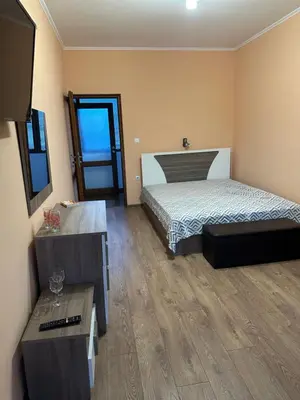 a bedroom with a bed and a television in it at Къща за гости Арнаудови in Kostandovo