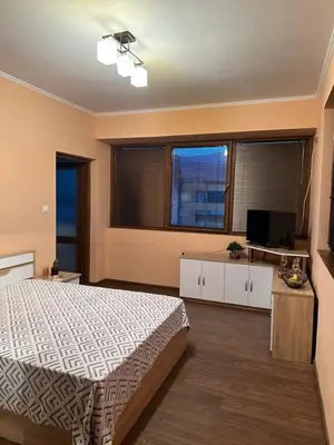 a bedroom with a bed and a large window at Къща за гости Арнаудови in Kostandovo