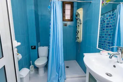 a blue bathroom with a toilet and a sink at Bellalux in Sandanski