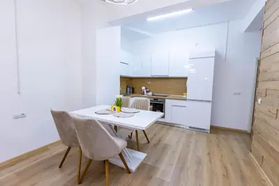 a kitchen and dining room with a white table and chairs at Bellalux in Sandanski