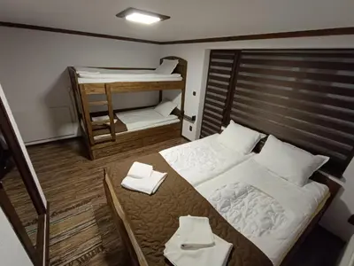 a small room with a bed and two bunk beds at Detached Guest House Рилски кът Маджаре in Madzhare