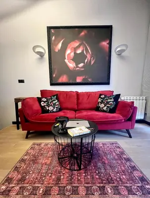 a red couch in a living room with a table at Flower house 9 in Sofia