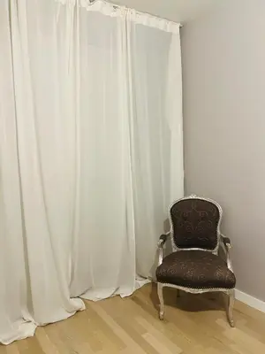 a chair sitting in front of a curtain at Flower house 9 in Sofia