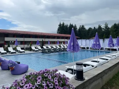 a hotel swimming pool with chairs and umbrellas at Paradise SPA Hotel in Tsigov Chark