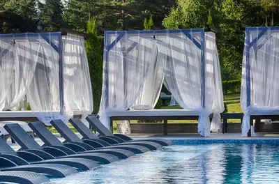 a row of chairs next to a swimming pool at Paradise SPA Hotel in Tsigov Chark