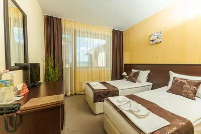 a hotel room with two beds and a desk at Paradise SPA Hotel in Tsigov Chark