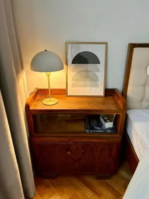 a nightstand with a lamp on it next to a bed at Chic Urban Retreat in Sofia