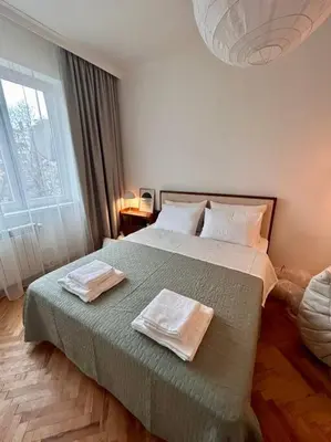 a bedroom with a bed with two towels on it at Chic Urban Retreat in Sofia