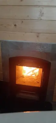a woodburning oven with a fire inside of it at Rodopi Guest House in Tsigov Chark