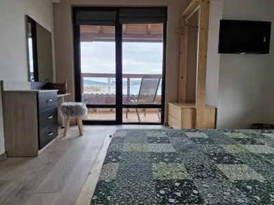 a bedroom with a bed and a view of a balcony at Rodopi Guest House in Tsigov Chark