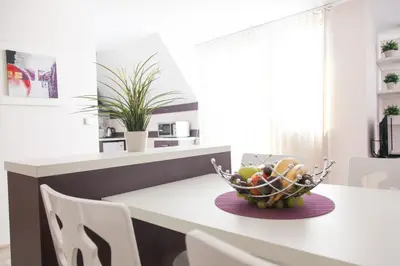 a kitchen with a bowl of fruit on a table at Sky Apartments in Blagoevgrad