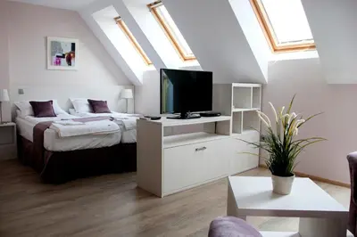 a bedroom with a bed and a television in a attic at Sky Apartments in Blagoevgrad