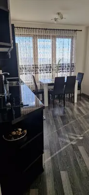a kitchen and dining room with a table and chairs at Black and White Apartment in Karlovo