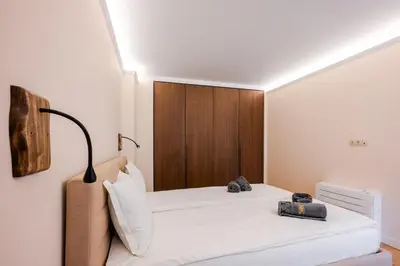 a bedroom with a bed with a wooden headboard at SOFapart Boutique Apartments in Sofia