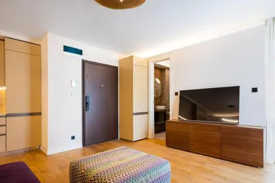 a living room with a large television and a ottoman at SOFapart Boutique Apartments in Sofia