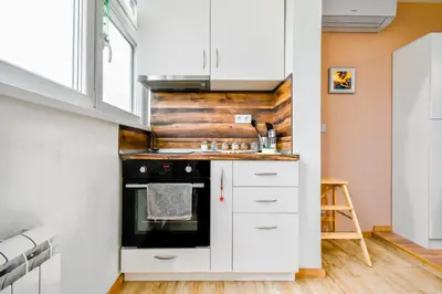 a kitchen with white cabinets and a stove at Doynov's Apartment in Sofia