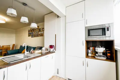 a kitchen with white cabinets and a microwave at Doynov's Apartment in Sofia