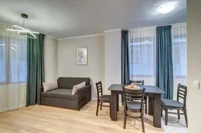 a living room with a couch and a table and chairs at Dream View Apartments in Pamporovo