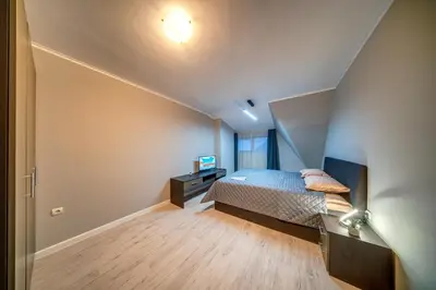 an attic bedroom with a bed and a television at Dream View Apartments in Pamporovo
