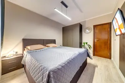a bedroom with a large bed and a television at Dream View Apartments in Pamporovo