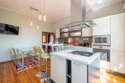 a kitchen with white cabinets and a table with chairs at Charming 2BDR Apartment in Historic Center With Parking in Sofia