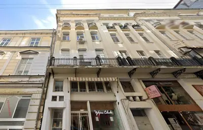a building with a balcony on the side of it at Charming 2BDR Apartment in Historic Center With Parking in Sofia