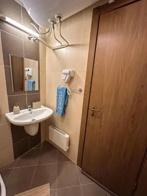 a bathroom with a sink and a wooden door at Bansko Ski Resort Apartment 2-3 people in Bansko