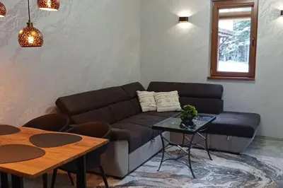 a living room with a couch and a table at АПАРТАМЕНТ WISH in Pamporovo