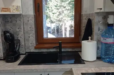 a kitchen counter with a sink and a window at АПАРТАМЕНТ WISH in Pamporovo