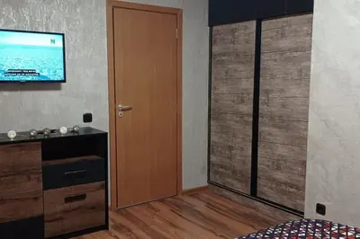 a room with a door and a television on a wall at АПАРТАМЕНТ WISH in Pamporovo