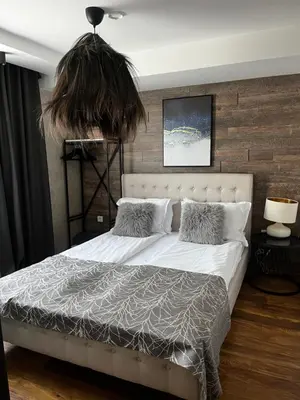 a bedroom with a large white bed with a plant above it at Valmont Luxury Chalet in Glozhene
