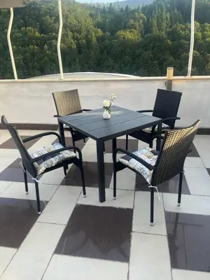 a black table and chairs sitting on a roof at Хотел Дикас in Smolyan