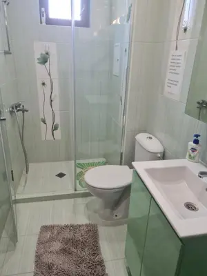 a bathroom with a shower and a toilet and a sink at Cozy apartment with balcony in Sofia