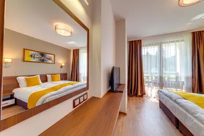 a hotel room with a bed and a mirror at OAK PARADISE in Smolyan