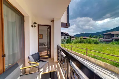 a balcony with a chair and a view of a field at OAK PARADISE in Smolyan