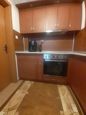 a kitchen with wooden cabinets and a black oven at Apartment Ceco in Troyan