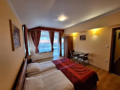 a bedroom with a large bed and a table at SNOW PEAK TODORKA AND VIHREN APARTAMENT /NEXT TO THE LIFT/ 7 PERSONS/ in Bansko