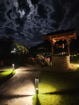 a stone pavilion with lights in a yard at night at SPA Hotel Daffi in Smolyan