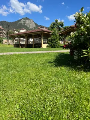 a large building with a grassy field in front of it at SPA Hotel Daffi in Smolyan