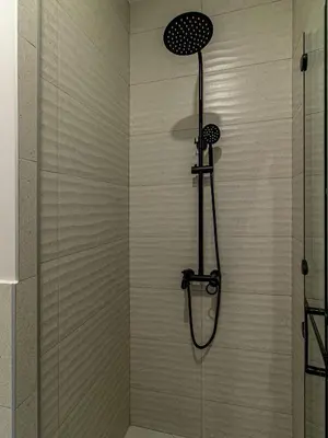 a shower with a shower head in a bathroom at Trocadero Touch: Sofia Hideaway in Sofia