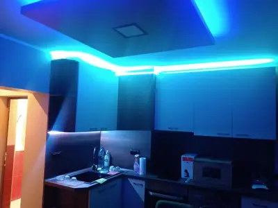 a kitchen with a blue light on the ceiling at Кръчмъ При Байката апарт in Teteven