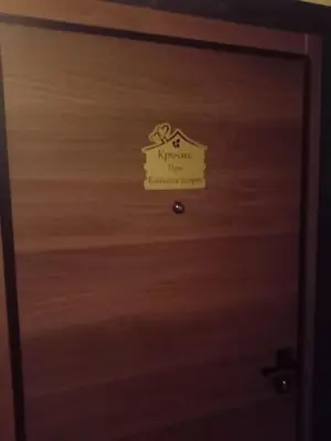 a wooden door with a sign on it at Кръчмъ При Байката апарт in Teteven
