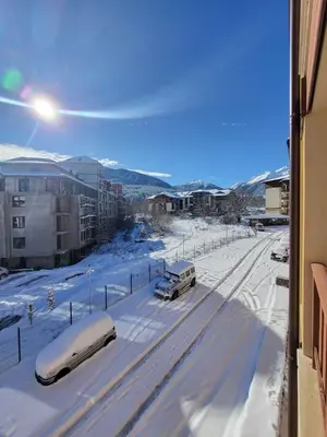 a street covered in snow with cars parked on it at Beautiful Apartment in Bansko