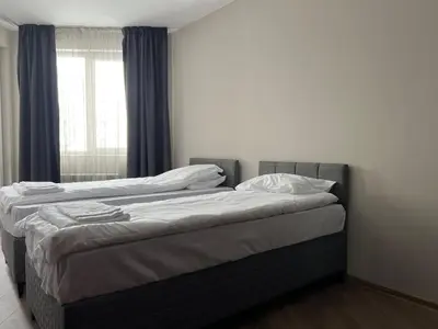 two twin beds in a room with a window at Elite Apartments Complex Iglika Borovets in Borovets