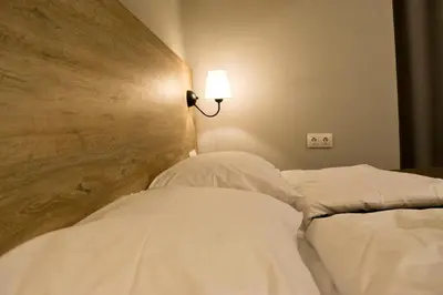 a bedroom with two beds and a light on the wall at Lofty - 1 bedroom apartment in the heart of Sofia in Sofia