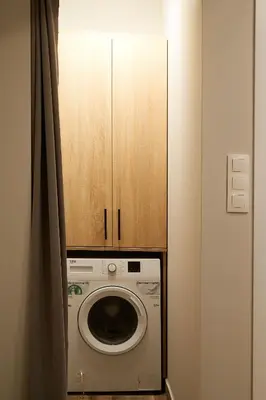 a washing machine with a wooden cabinet above it at Lofty - 1 bedroom apartment in the heart of Sofia in Sofia