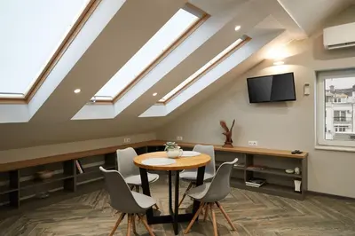 a room with a table and chairs and skylights at Lofty - 1 bedroom apartment in the heart of Sofia in Sofia