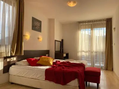 a bedroom with a bed with a red blanket on it at Banderitsa Apartment 2 in Bansko